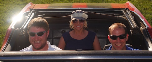 [Photo of smiling tour participants in convertible]